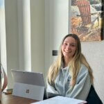 Student sitting by window and working on her laptop.