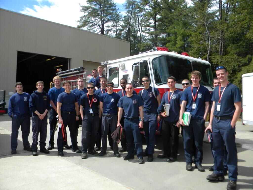 Fire students standing in front of a fire truck