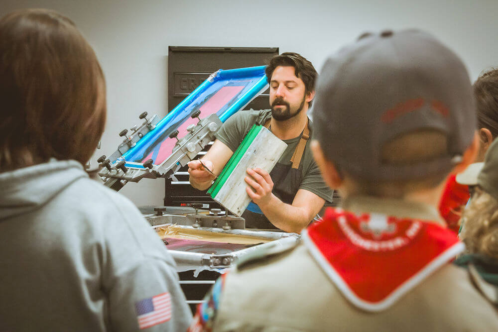 Scouting NH troop watching an instructor in a screen printing lab