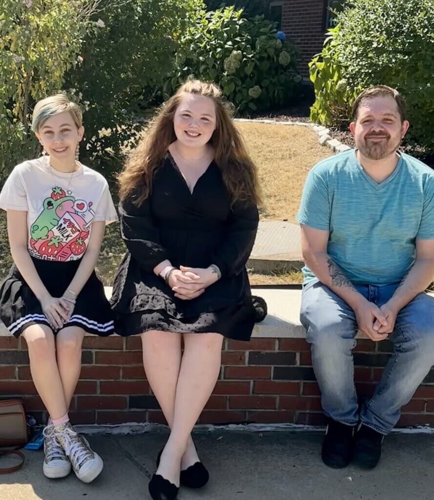 3 students sitting on a wall outside Turner Building