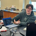 Student presenting his capstone project on his laptop