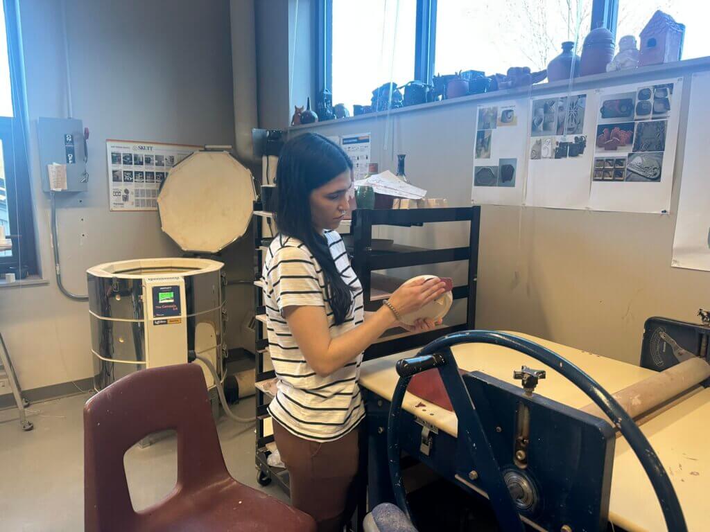 Student working on pottery dish