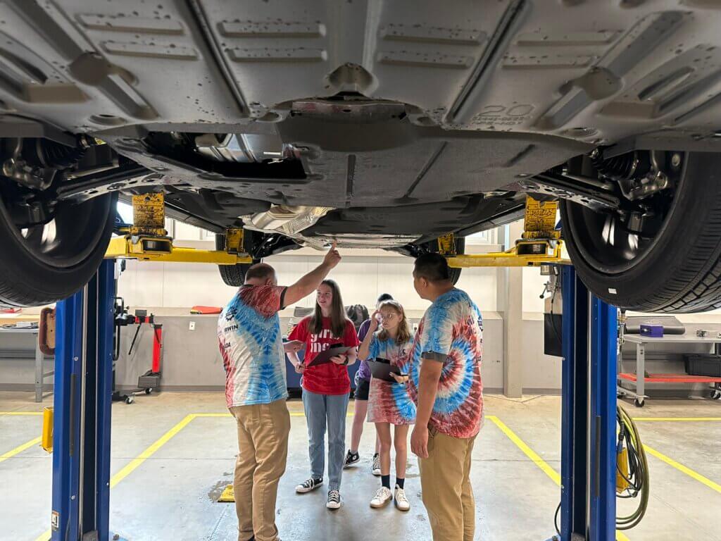 Girls Inc. campers under car