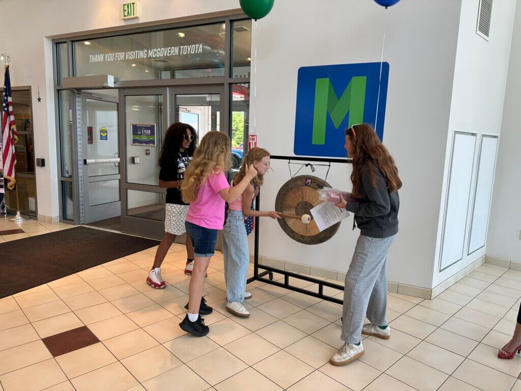 Girls Inc campers ringing the gong after a sale