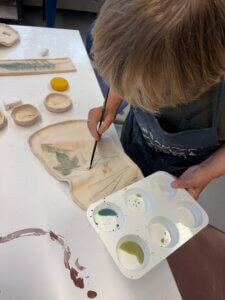 Student painting in ceramics